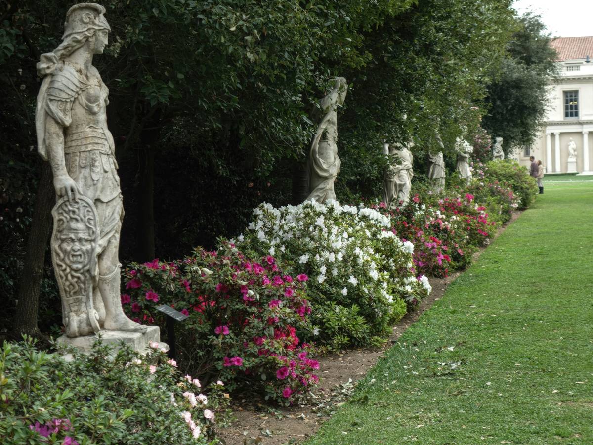 rustic cast stone garden statues for outdoor decor nestled among lavender and boxwood hedges