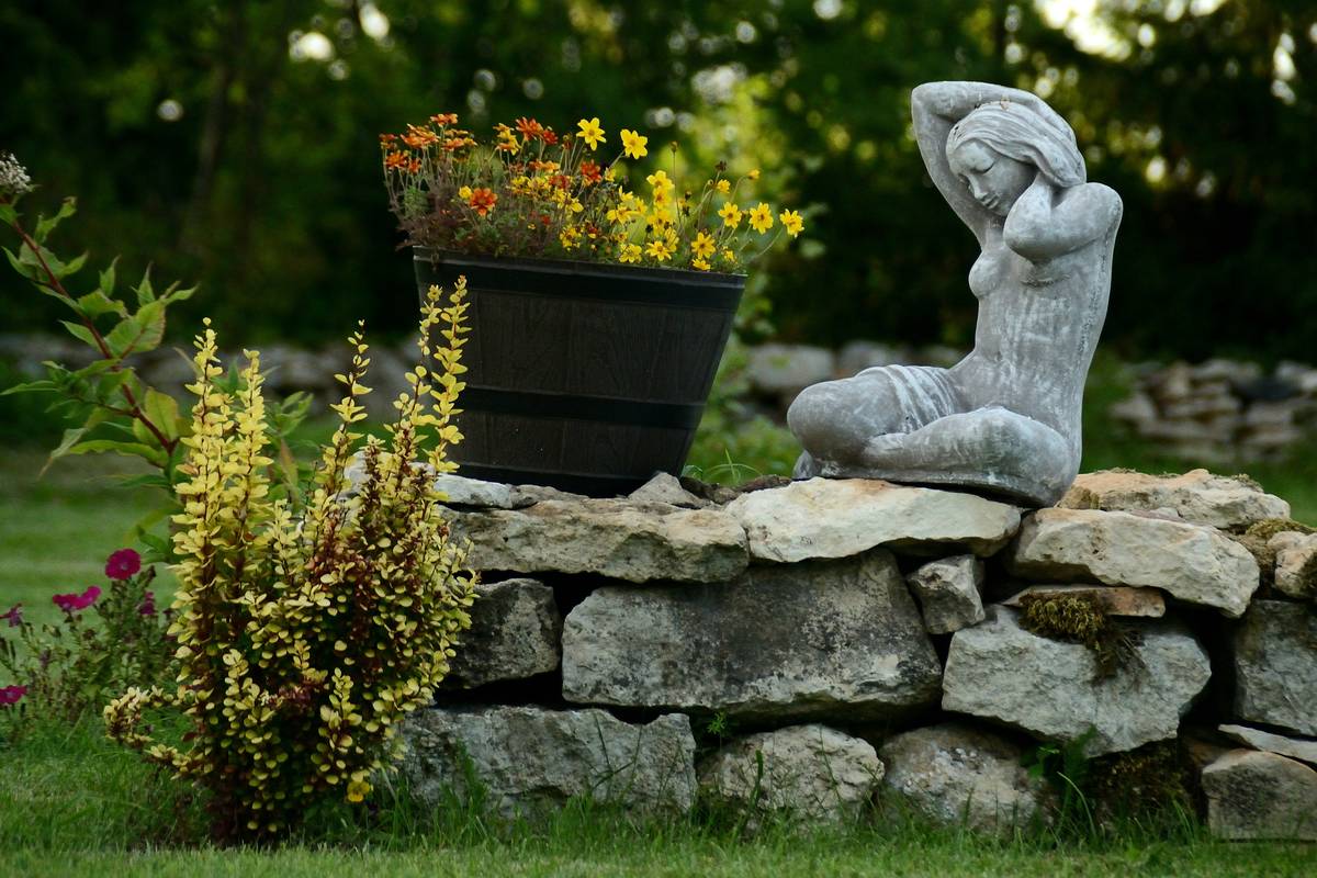 modern corten steel garden statues for outdoor decor reflecting sunset light in minimalist backyard