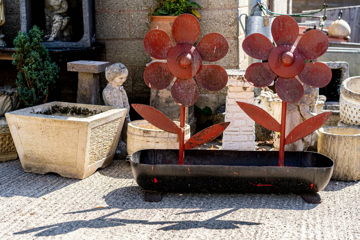 home depot outdoor ornaments including ceramic planters, metal sculptures, and stone statues arranged in a backyard setting